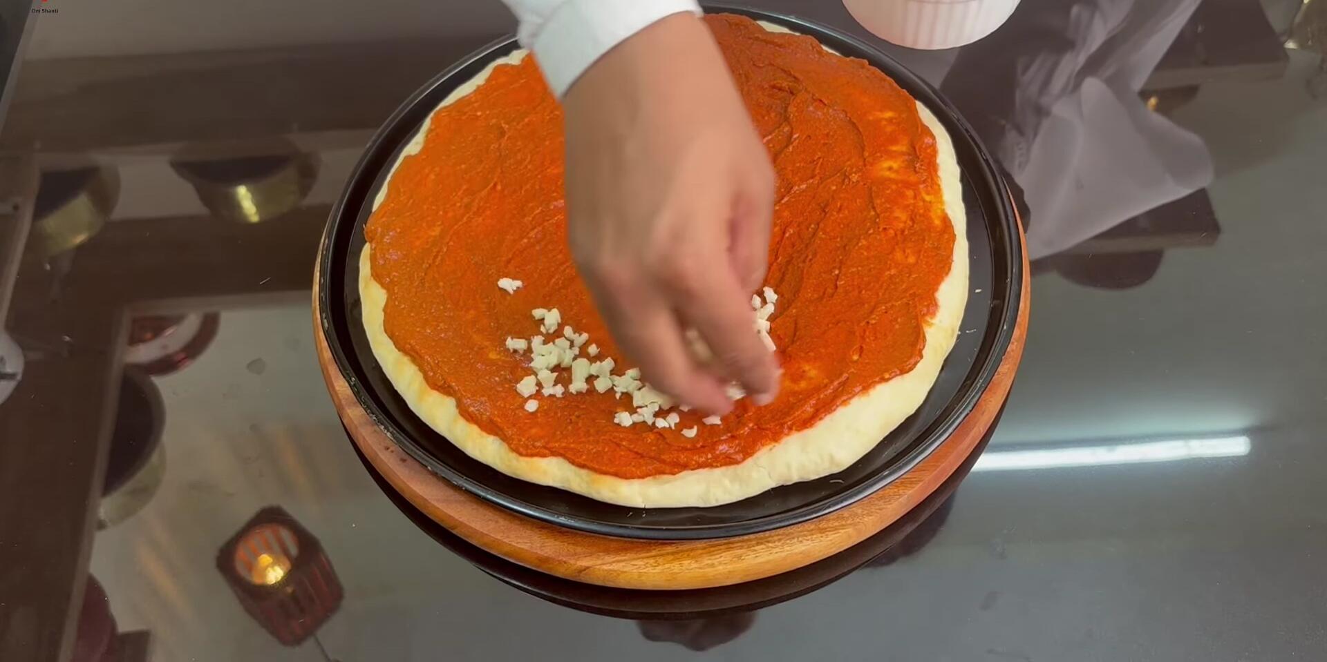 Adding the cheese to the pizza.