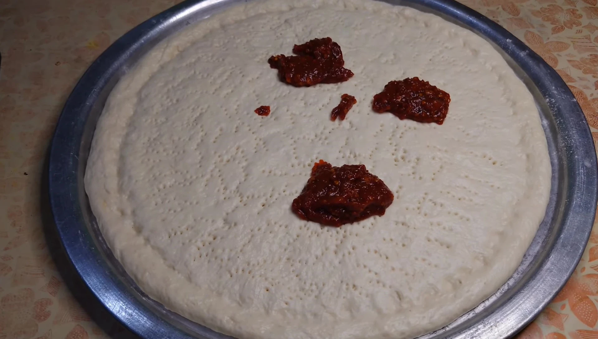 Adding sauce and toppings to the pizza