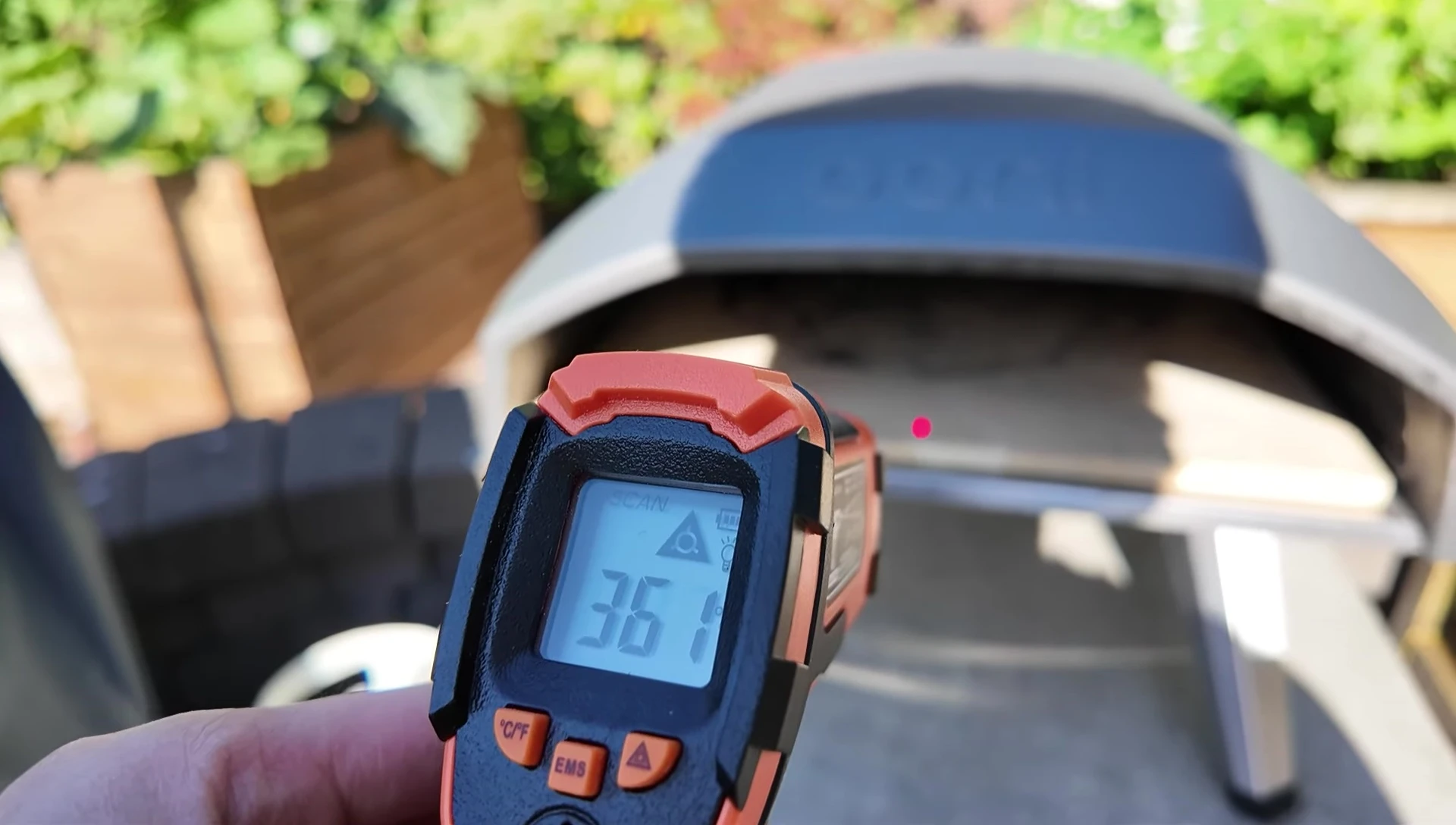 Using a heat gun to check the pizza stone's temperature.