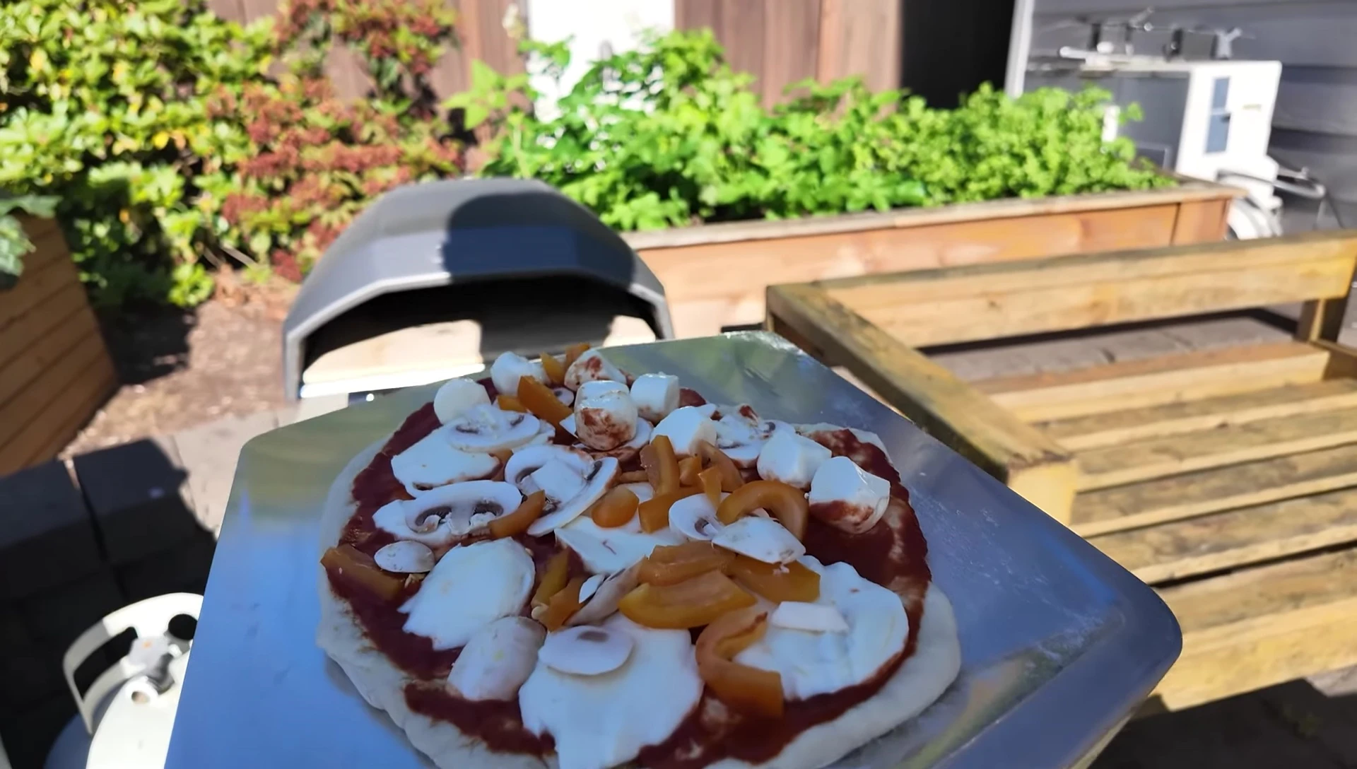 Pizza being placed in the Ooni Koda 12.
