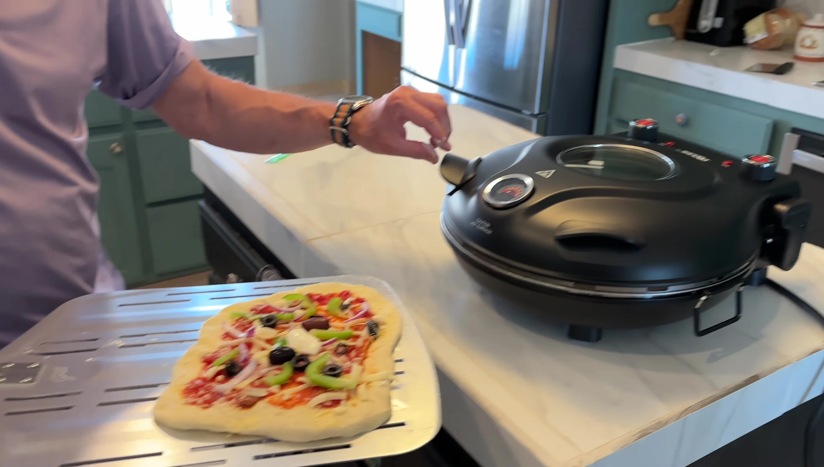 First pizza being placed in the oven.