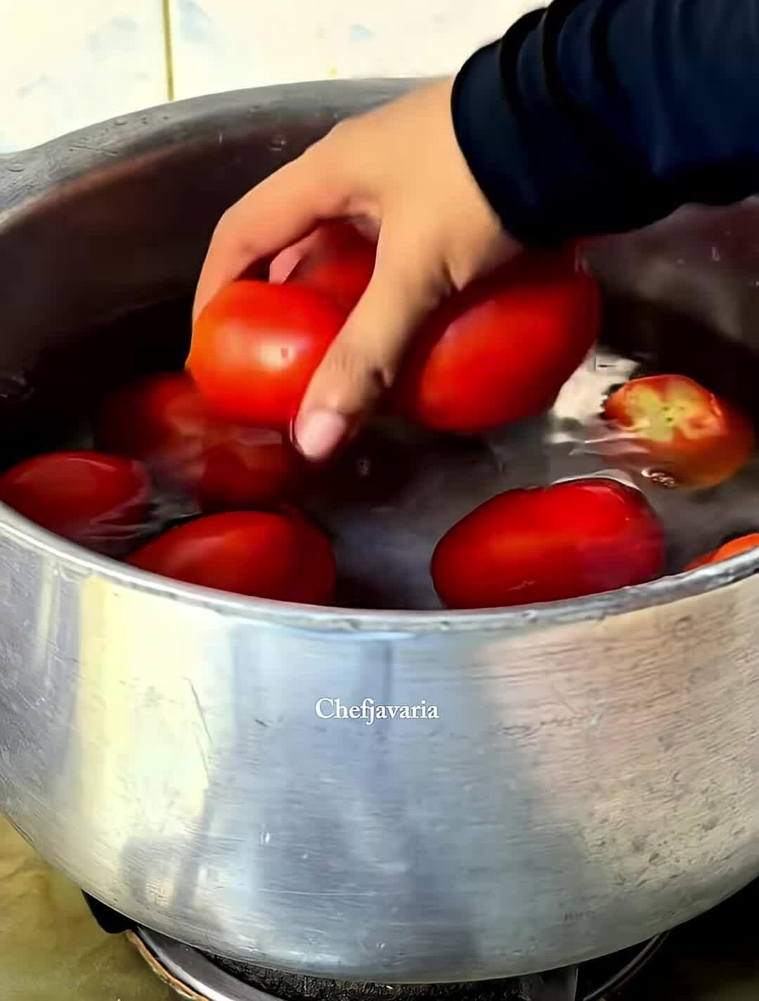 Adding tomatoes to boiling water.